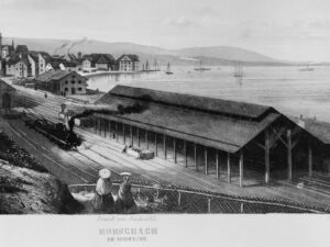 Après un temps passé sur les rives du lac de Constance, des sections du hall de la gare de Rorschach furent déplacées à Glaris en 1861 pour y être réutilisées. Gravure de 1856.