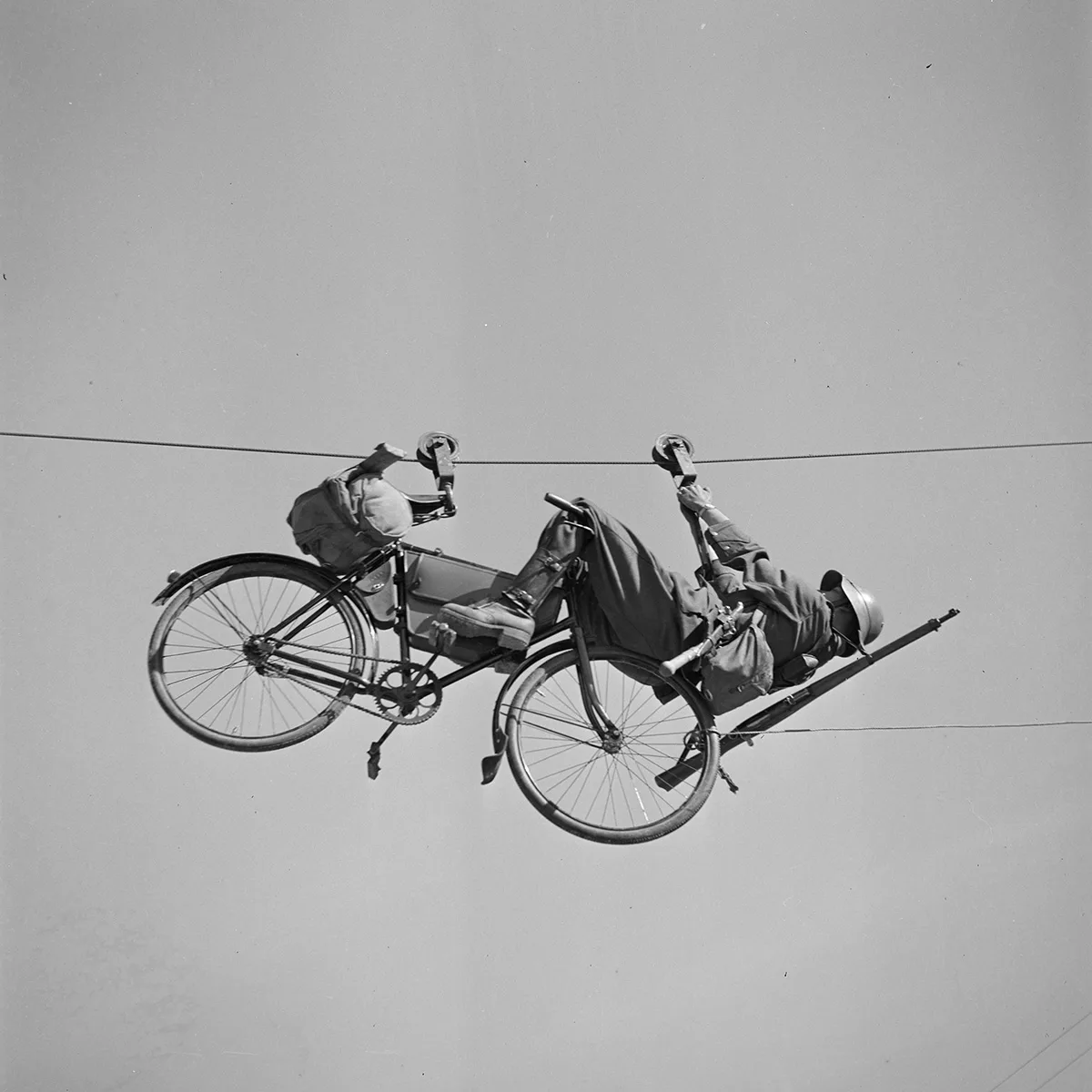 A soldier with his bike on a Tyrolean (zipline), circa 1935. Photo by Karl Egli.