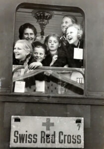 Evacuees at the window of a train carriage organised by the Swiss Red Cross, c. 1944.