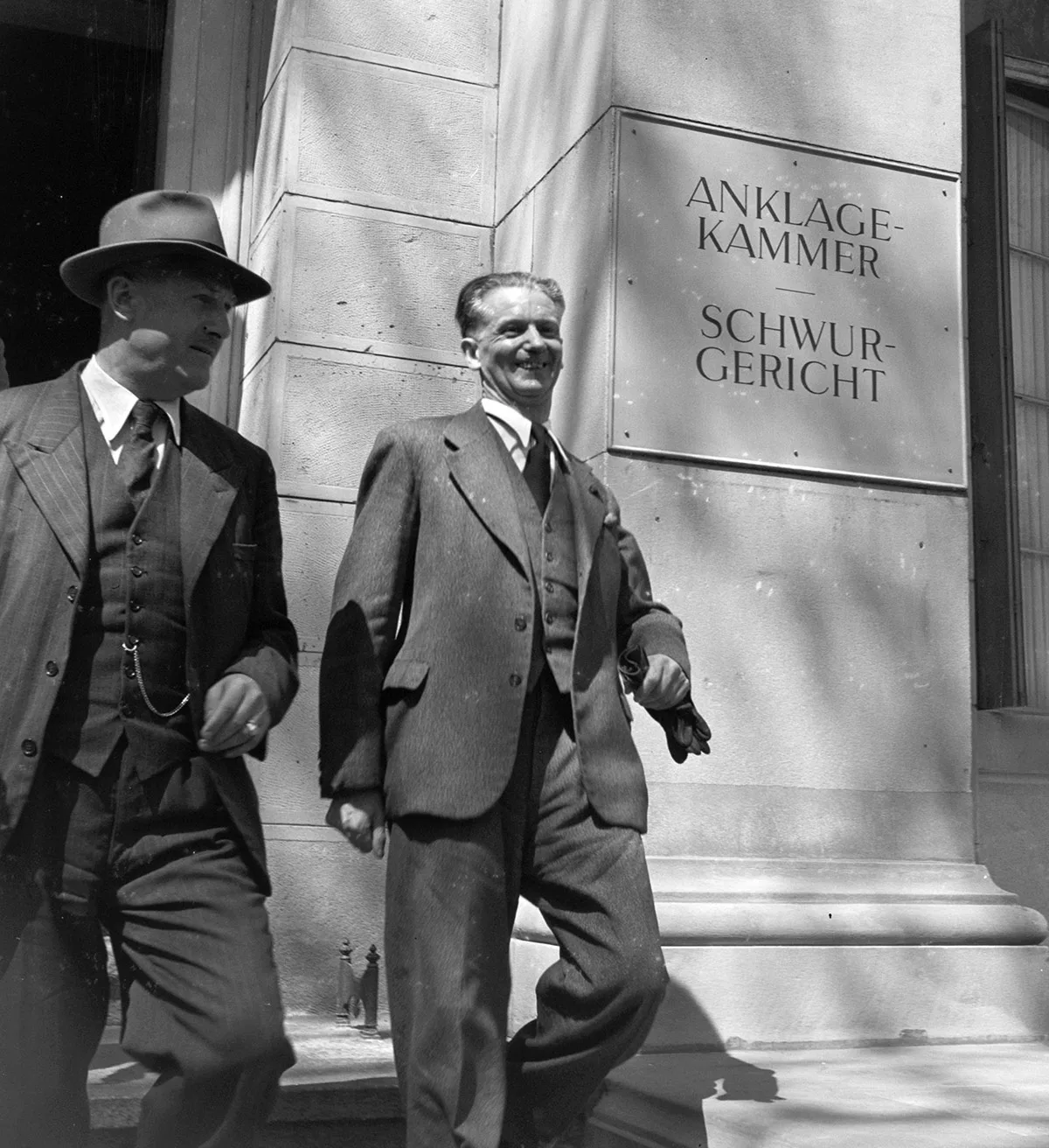 Franz Burri (rechts) verlässt nach einer ersten Anhörung am 21. April 1948 den Gerichtssaal in Zürich.