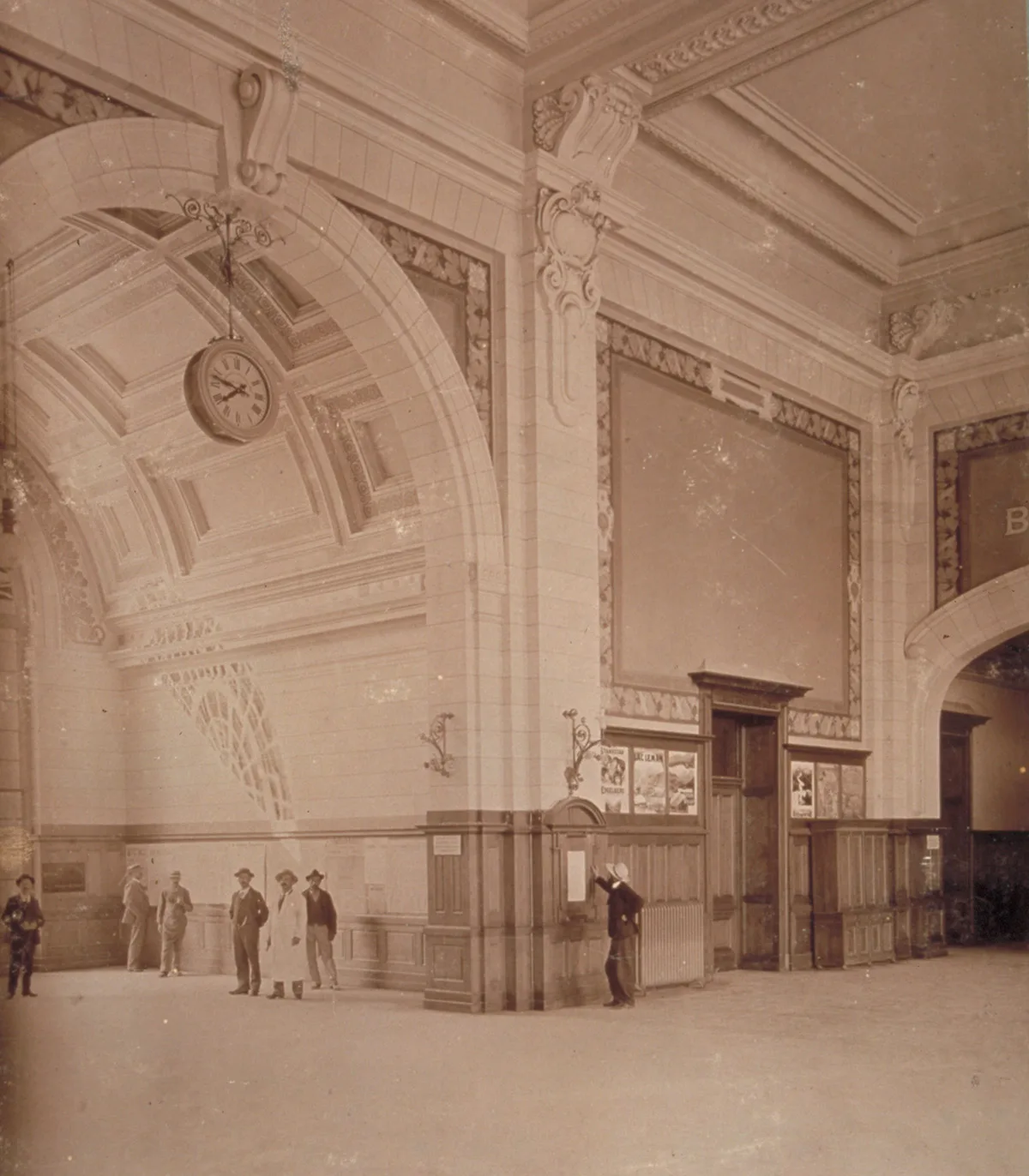 Bahnhofshalle von La Chaux-de-Fonds mit grosser Uhr um 1900.