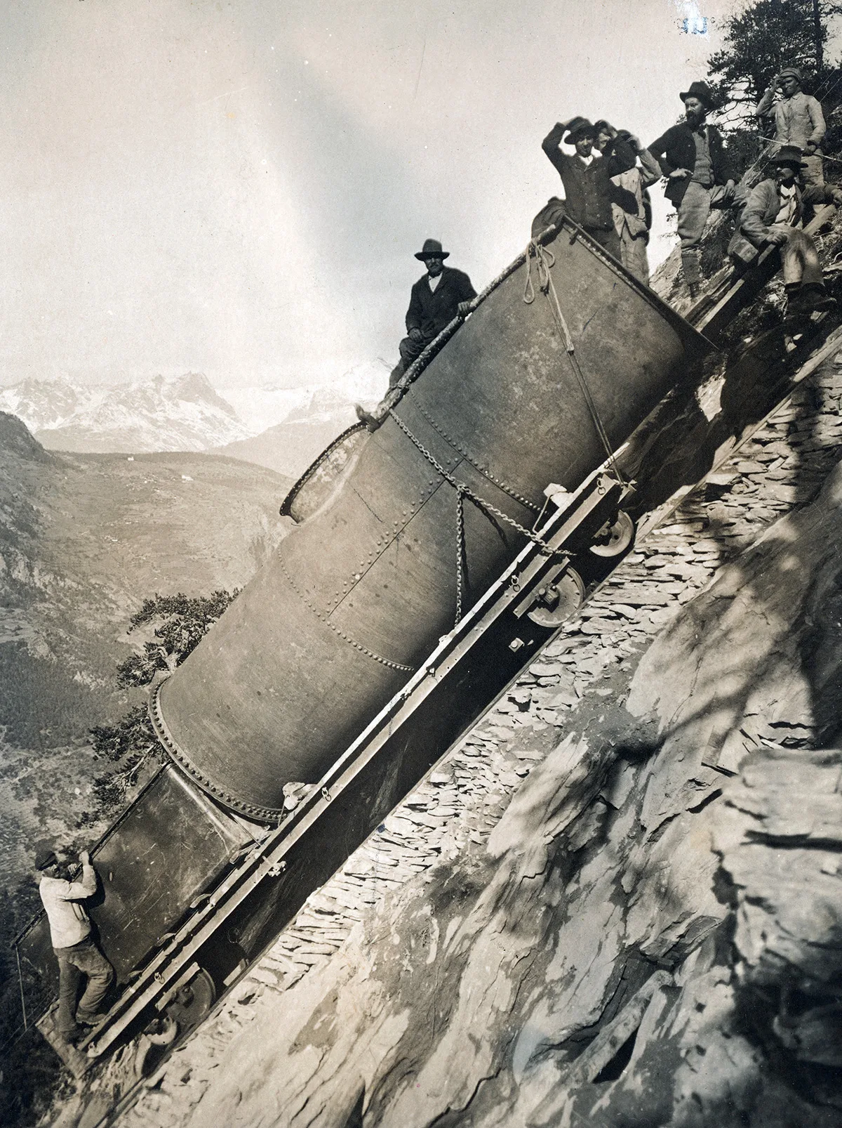 Für den Bau des Wasserkraftwerks im Ackersand, Wallis wird eine Druckröhre den Berg hochgeschafft, um 1922.