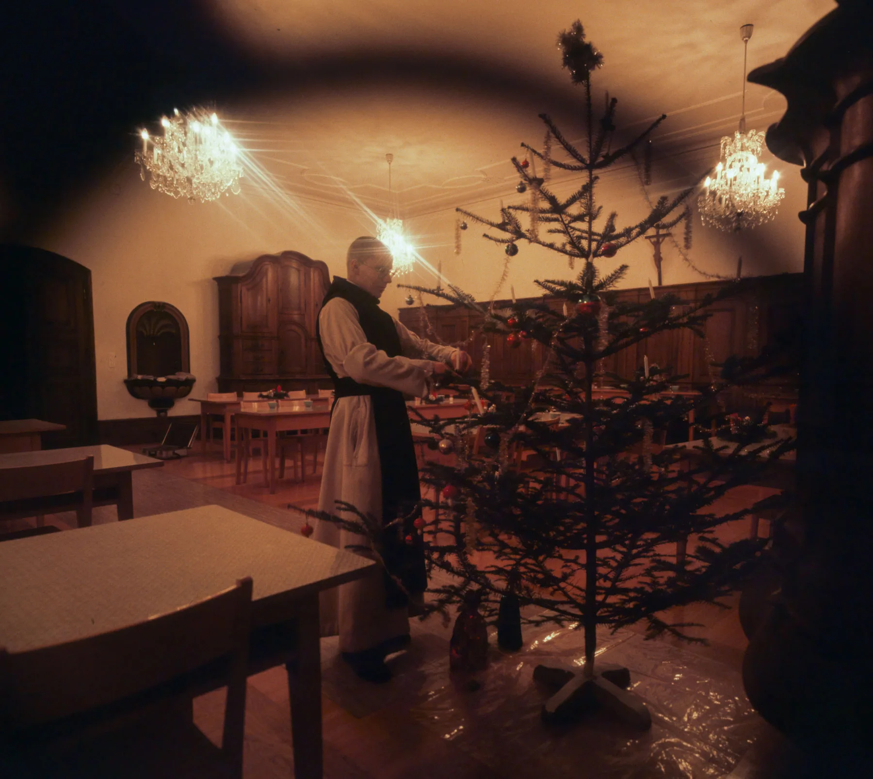 Ein Mönch schückt einen Weihnachtsbaum im Kloster Hauterive (FR), 1977.
