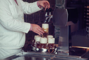 Un restaurateur sert une bière, vers 1980.