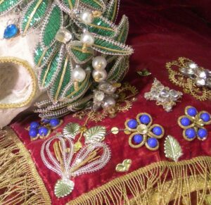 Détail des ornements en fils, broderies, perles de verre et inserts de bijoux des reliques de sainte Clara.
