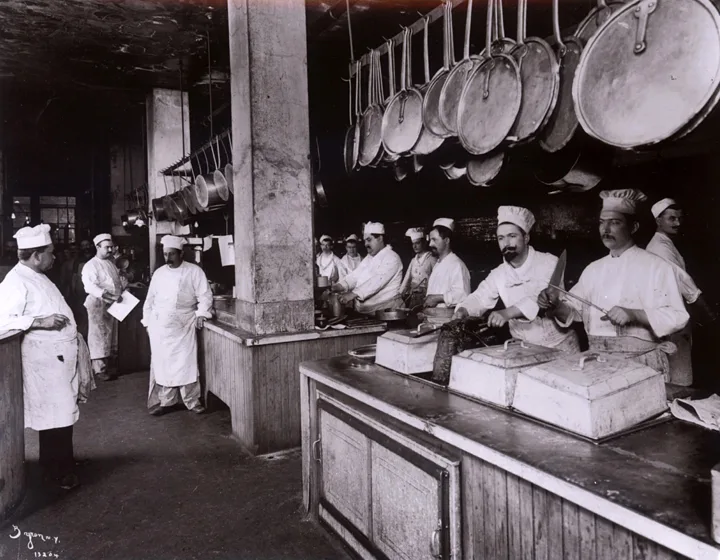 Un coup d’œil dans les cuisines de Delmonico’s en 1902. Sur la photo de droite, des chefs pâtissiers confectionnent des pièces montées dans la pâtisserie.