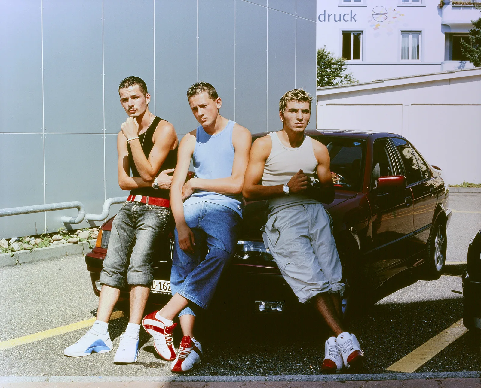 The post-Yugoslavian influence is especially prevalent in youth culture. Young men with a Kosovan-Albanian background posing in front of a BMW. Photo by Paco Carascosa, 2004.