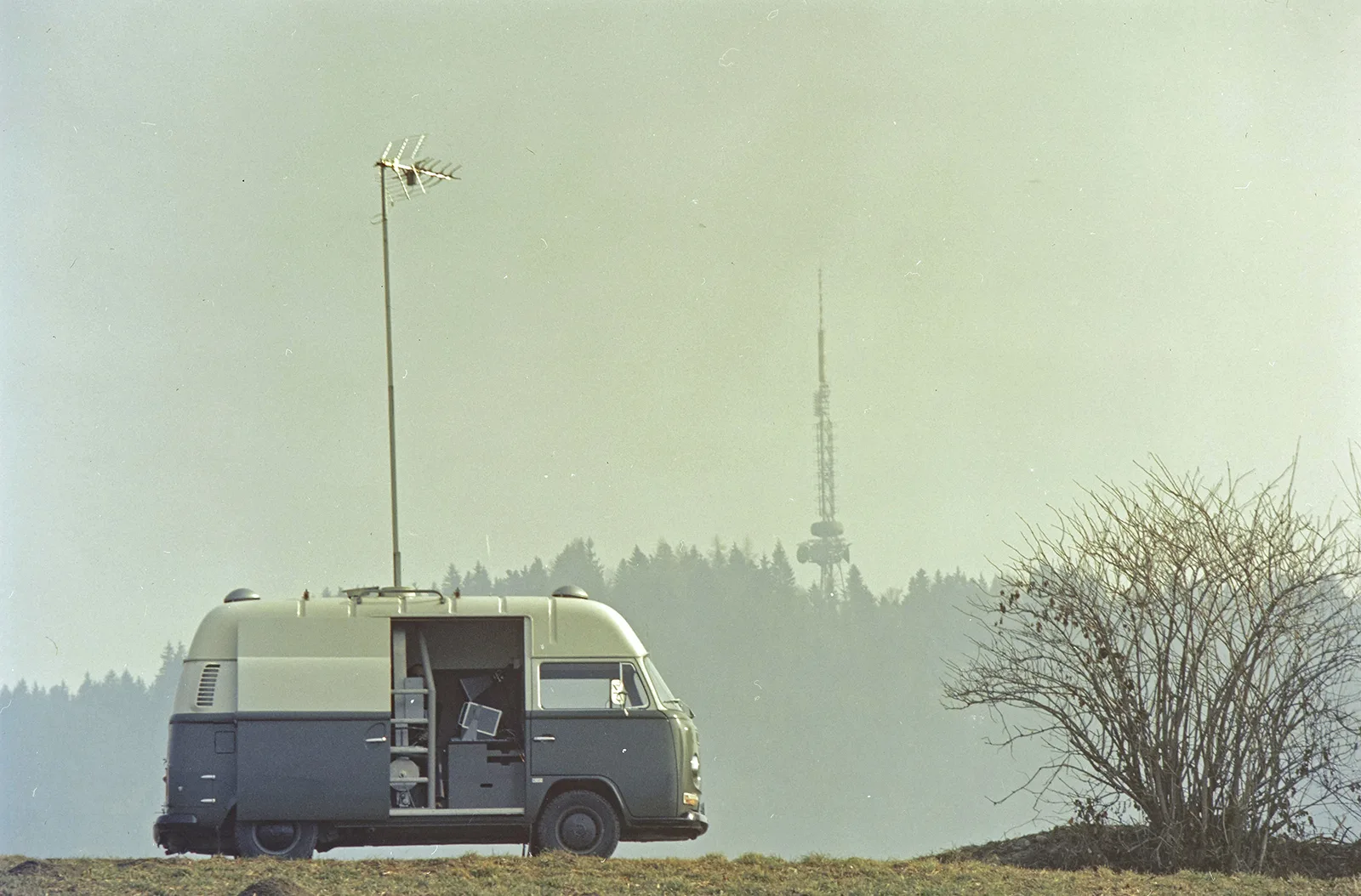 Ein Peilwagen der PTT vor dem Bantiger Sendeturm im Jahr 1976. Der Turm prägt die Silhouette des Hügels markant.