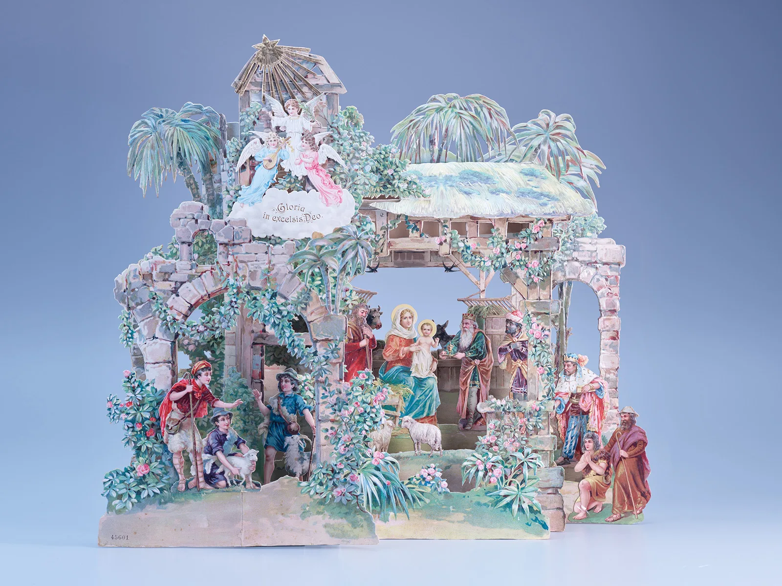 In dieser Faltkrippe ist die Heilige Familie von einer halbzerfallenen Steinarchitektur umgeben, die von Palmen und blühenden Kletterpflanzen überwuchert wird. Die Krippe aus Karton und Papier wurde um 1900 hergestellt und stammt aus der Weihnachtssammlung Doris Albrecht-Mäder, Männedorf.