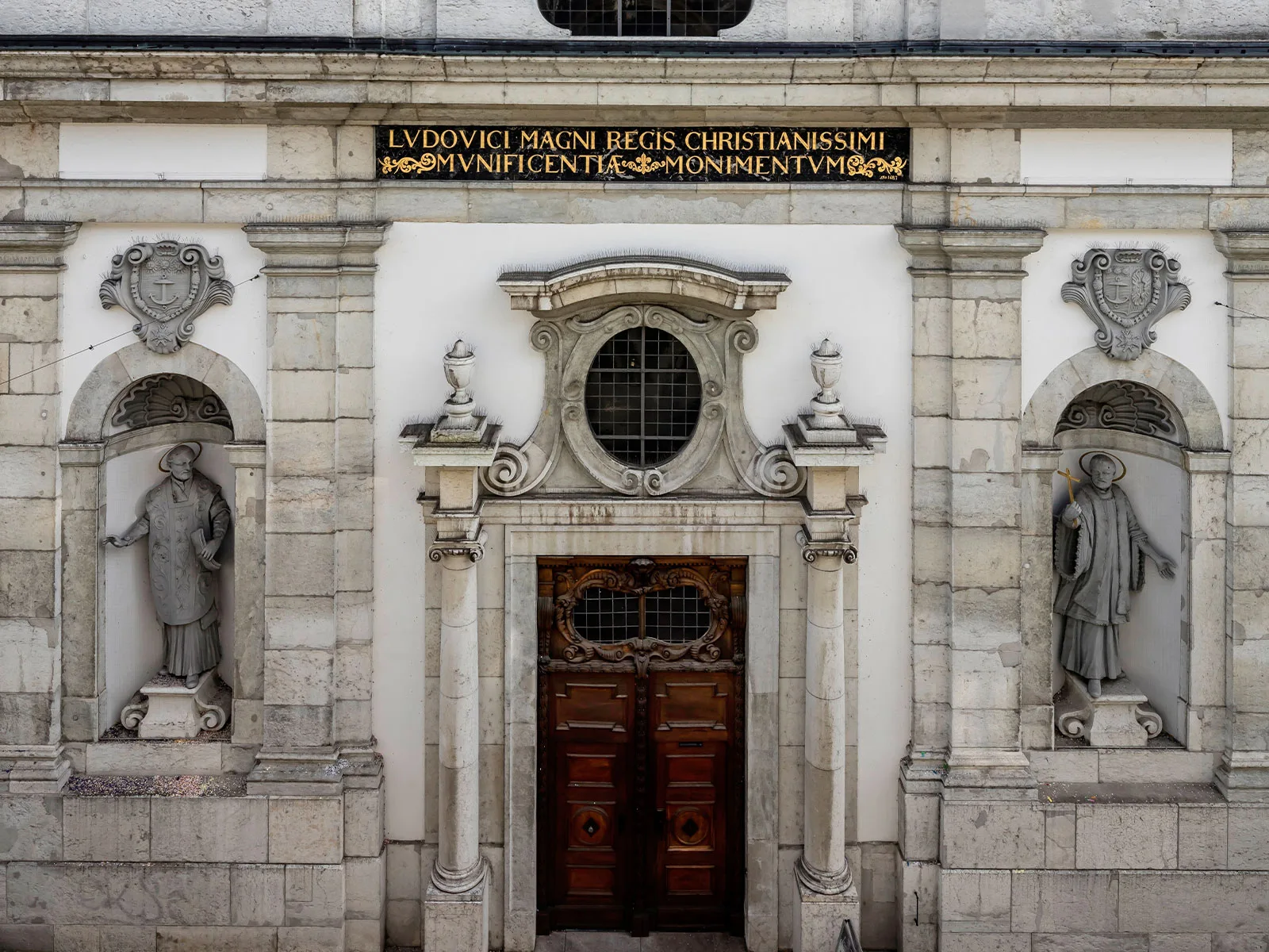 Fassade der Jesuitenkirche Solothurn im Zustand von 2023 mit der restaurierten Inschrift von Ludwig XIV. und den Wappen des Ambassadoren und seiner Frau.