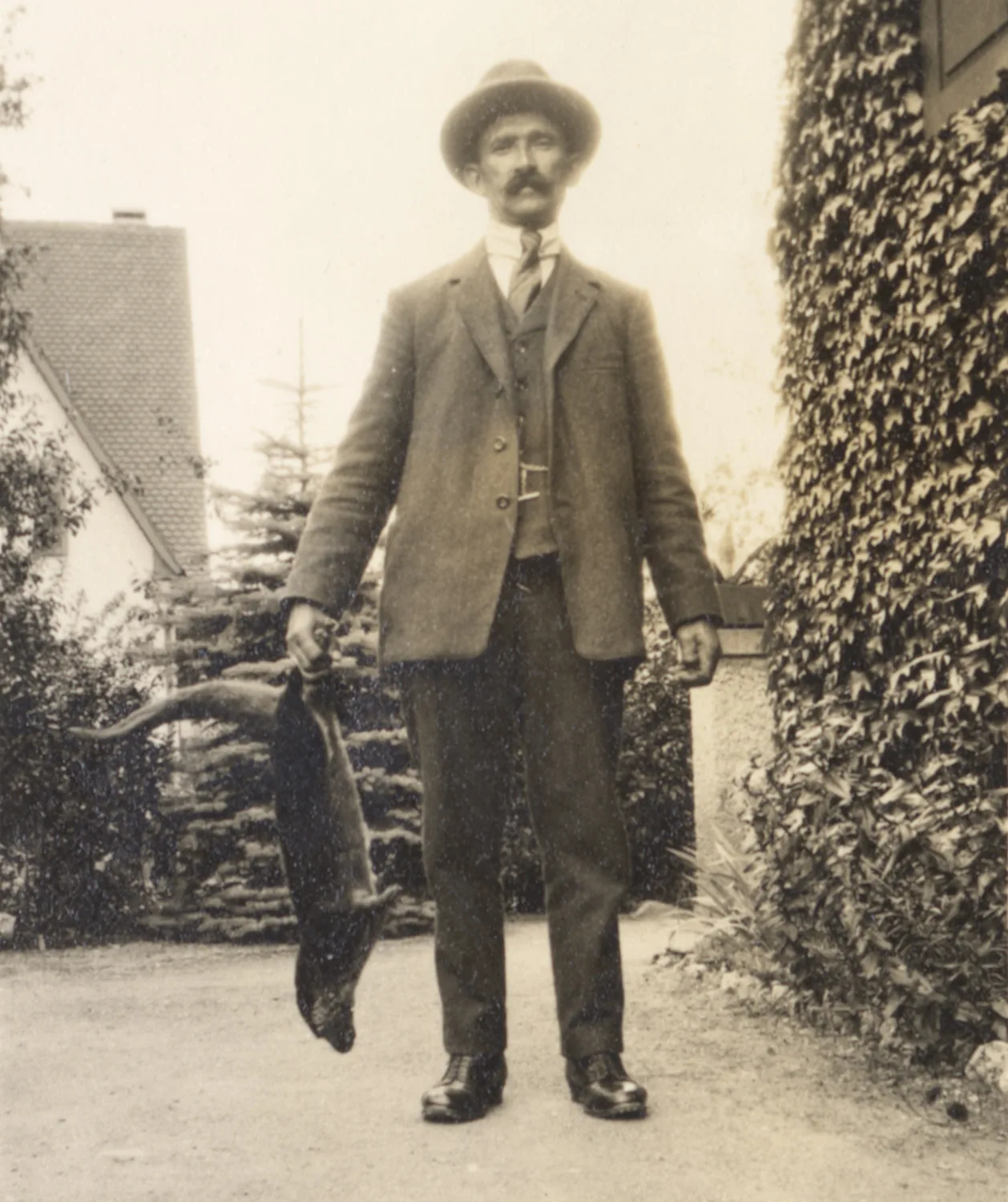 Der Jäger Rudolf Plattner posiert mit einem erlegten Fischotter in Reigoldswil, 1927.