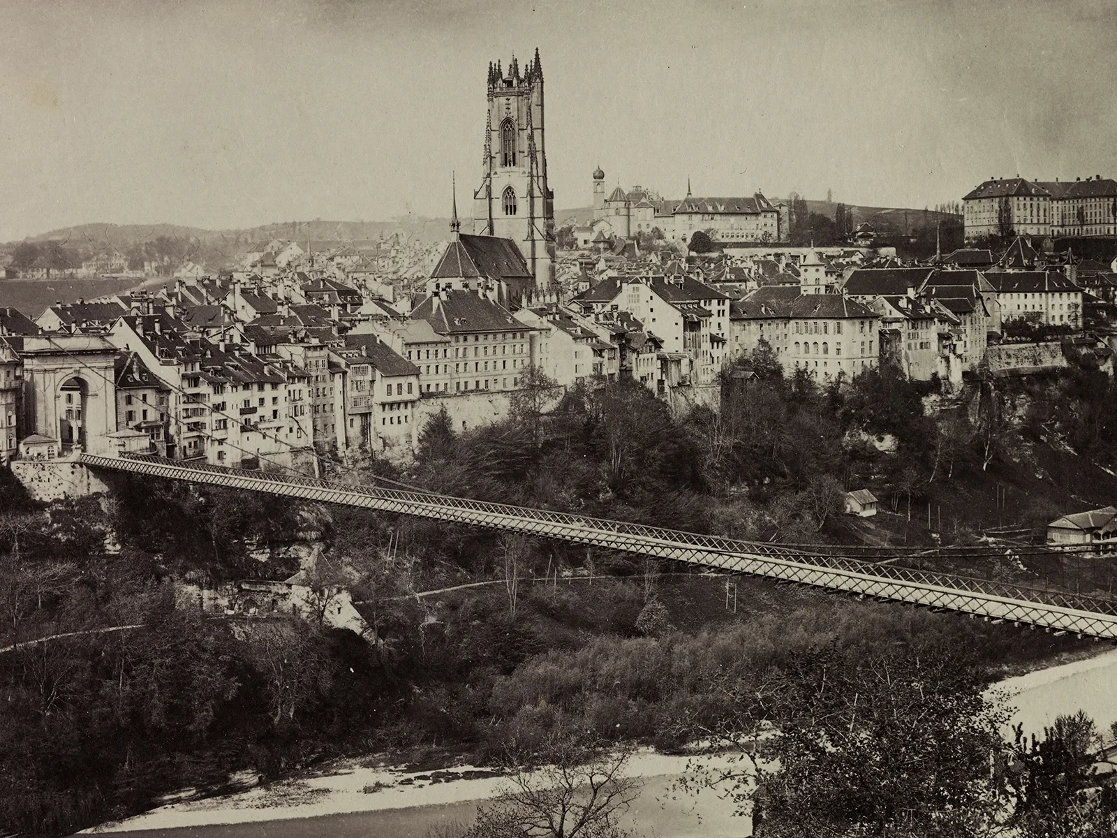 Freiburg um 1900. In der Mitte die Stiftskirche St. Nikolaus und Staatskanzlei, im Vordergrund die Grand Pont suspendu.
