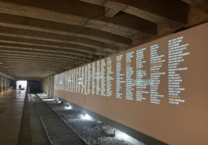 The underground platform 21 originally housed the post office. The wagons were loaded and brought to the surface in a lift. A “Wall of Names” now commemorates the people who were deported from there to the Auschwitz-Birkenau concentration camp. The names of the few survivors are written in orange.