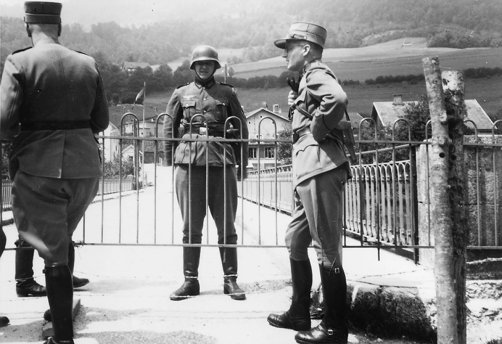 Two members of the Swiss Armed Forces and a member of the German Wehrmacht at the border between France and Switzerland near Goumois (canton of Jura), 1940.