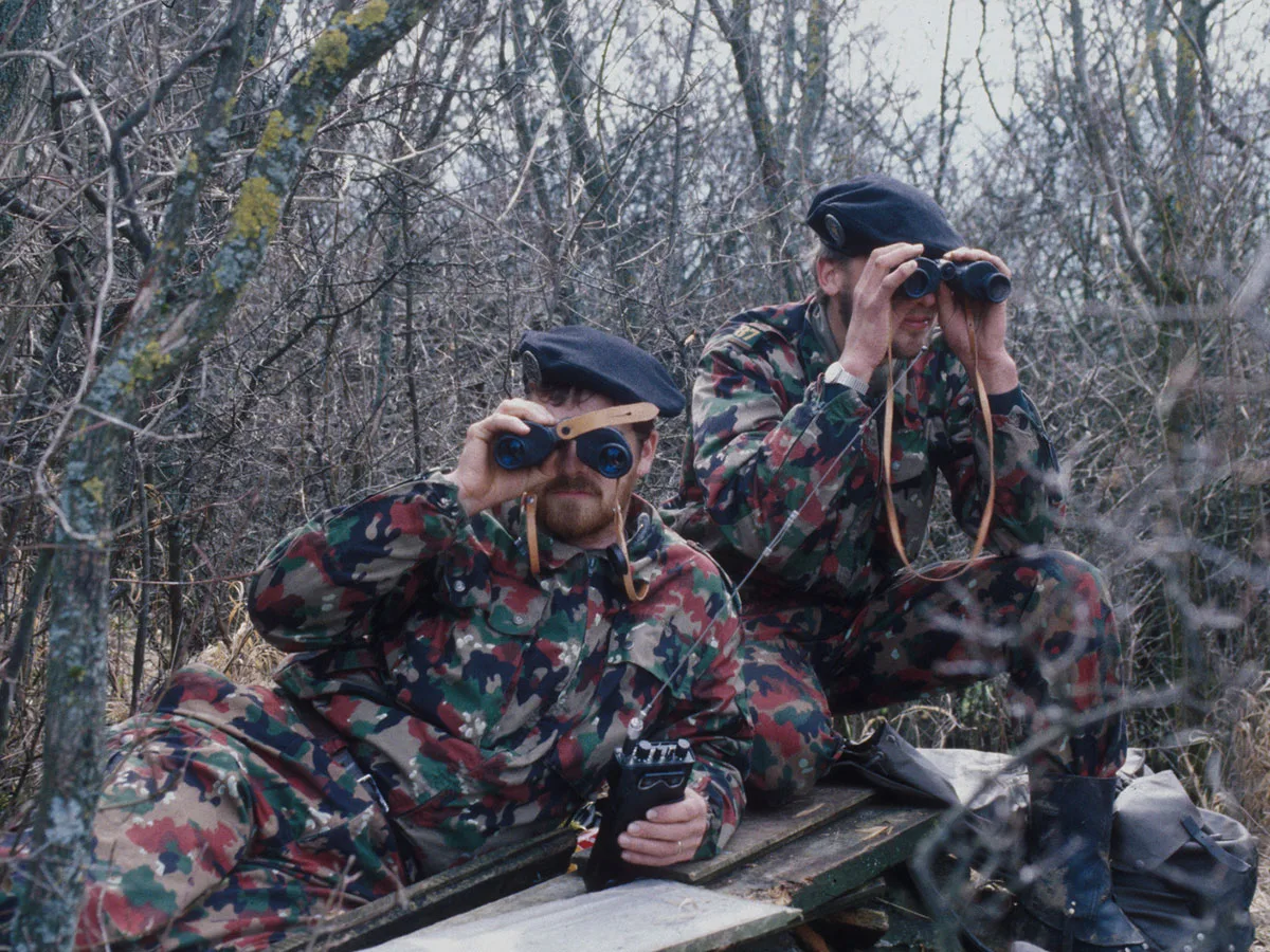 Surveillance in the border area: soldiers in action on the ‘green border’, 1991. Between the shrubbery and leafless branches, this shows how Alpenflage was designed to break up the contours of the uniform in the terrain.
