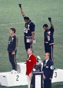 Les sprinters américains Tommie Smith et John Carlos avec le poing levé, le salut du Black Power, lors de la cérémonie de remise des prix du 200 mètres aux Jeux Olympiques de 1968.