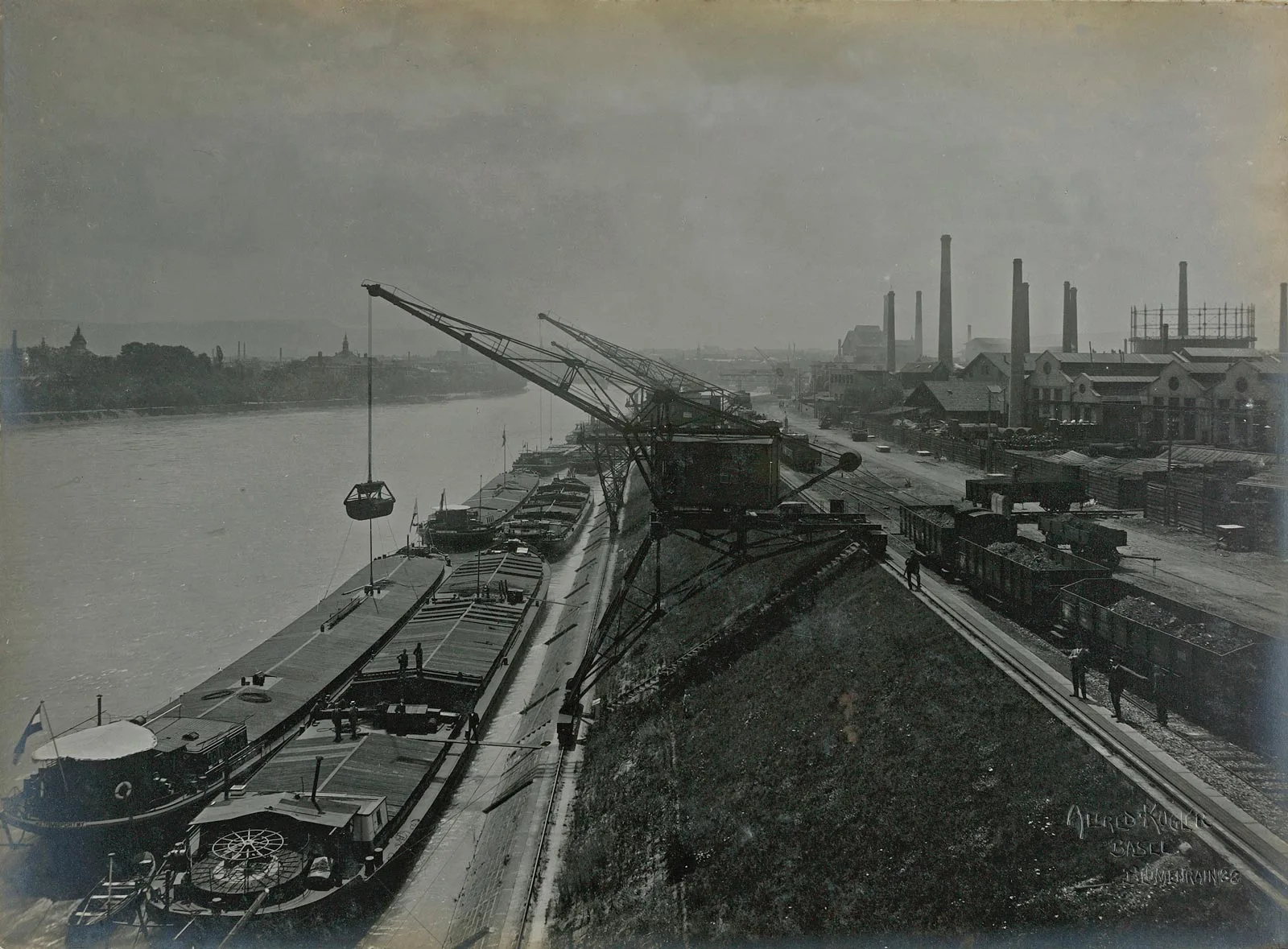Grues transbordant les marchandises depuis les bateaux vers les wagons de fret dans le port de St. Johann, 1919.