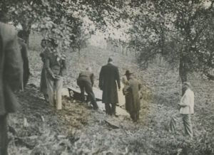 Photo de Willy Rogg: Le corps de la reine Astrid (sous un tissu blanc) est soulevé dans un cercueil.