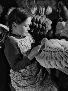Fillette en train de tisser des chaussettes, vers 1940.