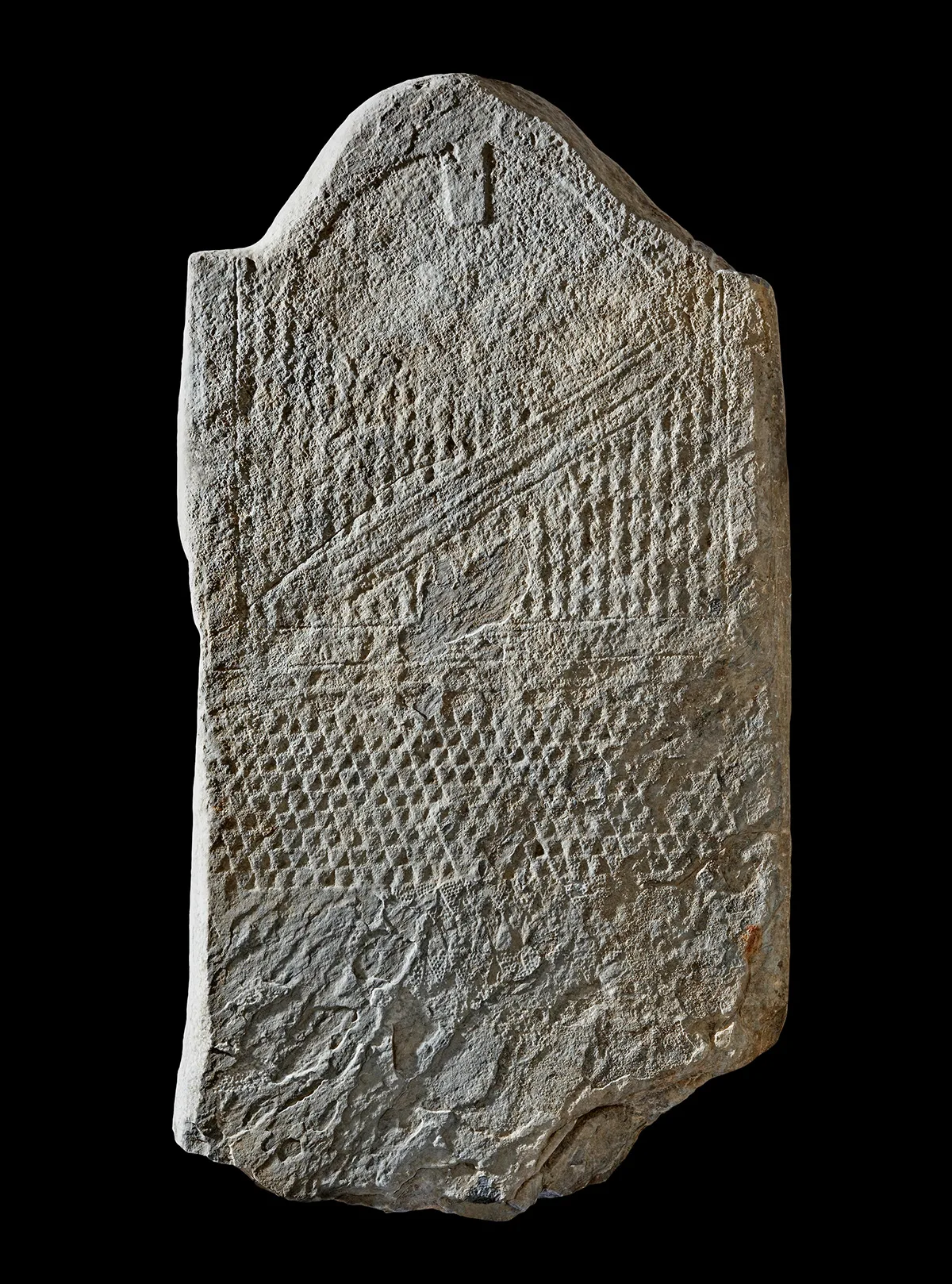 Männliche Stele «Petit-Chasseur 25» mit T-förmigem Gesicht, gemustertem Gewand, Pfeil und Bogen. Marmor. 2500–2200 v. Chr. Schweiz, Kanton Wallis, Sitten.