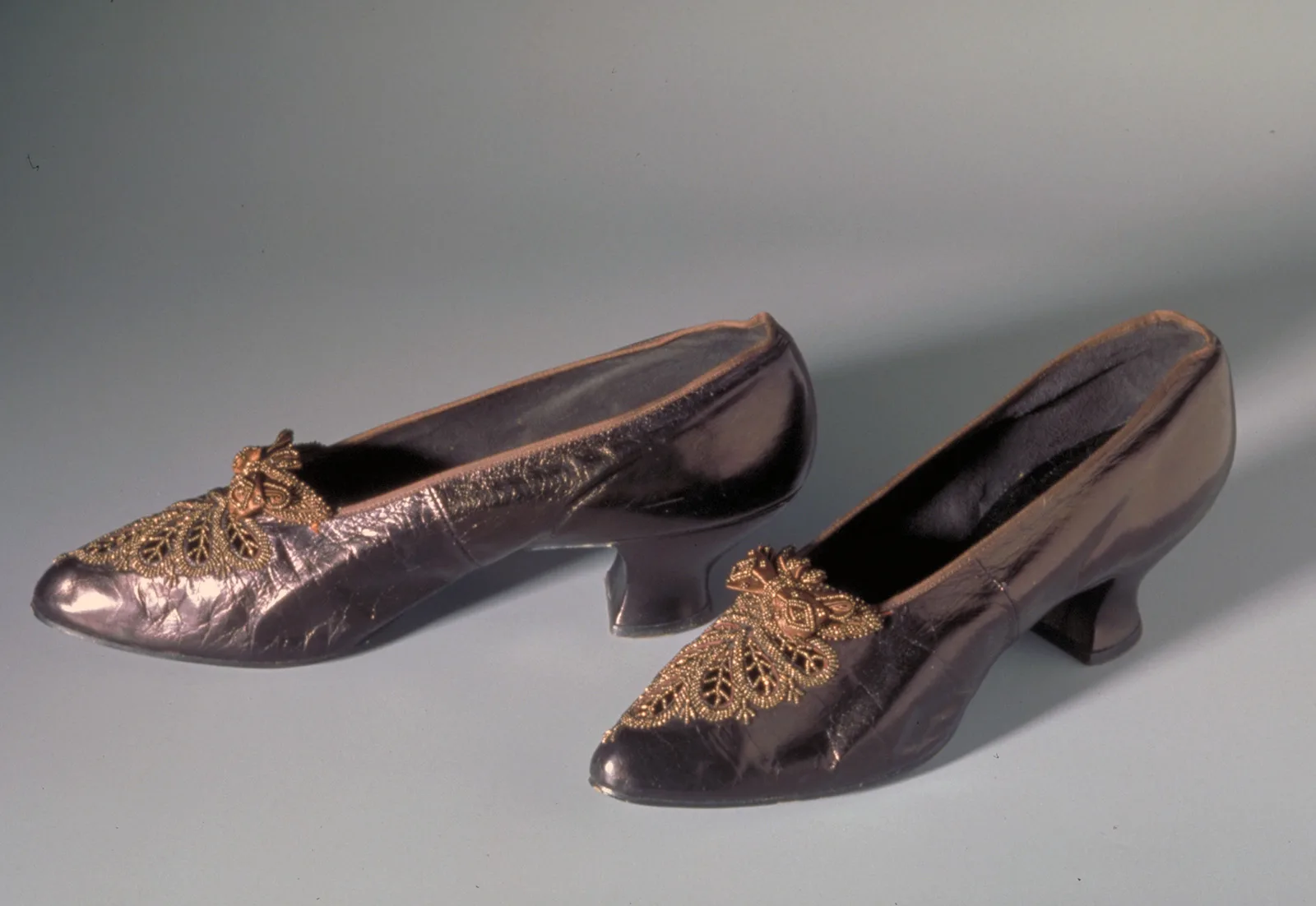 Um 1920 in der Schweiz für den Binnenmarkt gefertigt: Pumps aus «Goldkäferleder» von Bally. Die Schuhe sind mit filigranen Metallperlenstickereien in Blattform dekoriert.