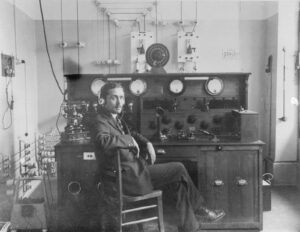 Roland Pièce devant le poste de contrôle de l’émetteur «Champ-de-l’Air» à Lausanne. Cliché pris vers 1923. L’installation se trouve aujourd’hui au Musée ENTER de Soleure.