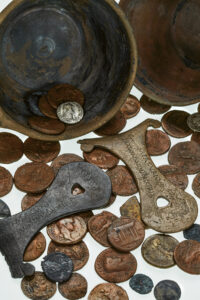 Pièces de monnaie romaine et écopes romaines retrouvées dans l’installation de captage de la source Grosse Heisse Stein en 1967 et 1968.