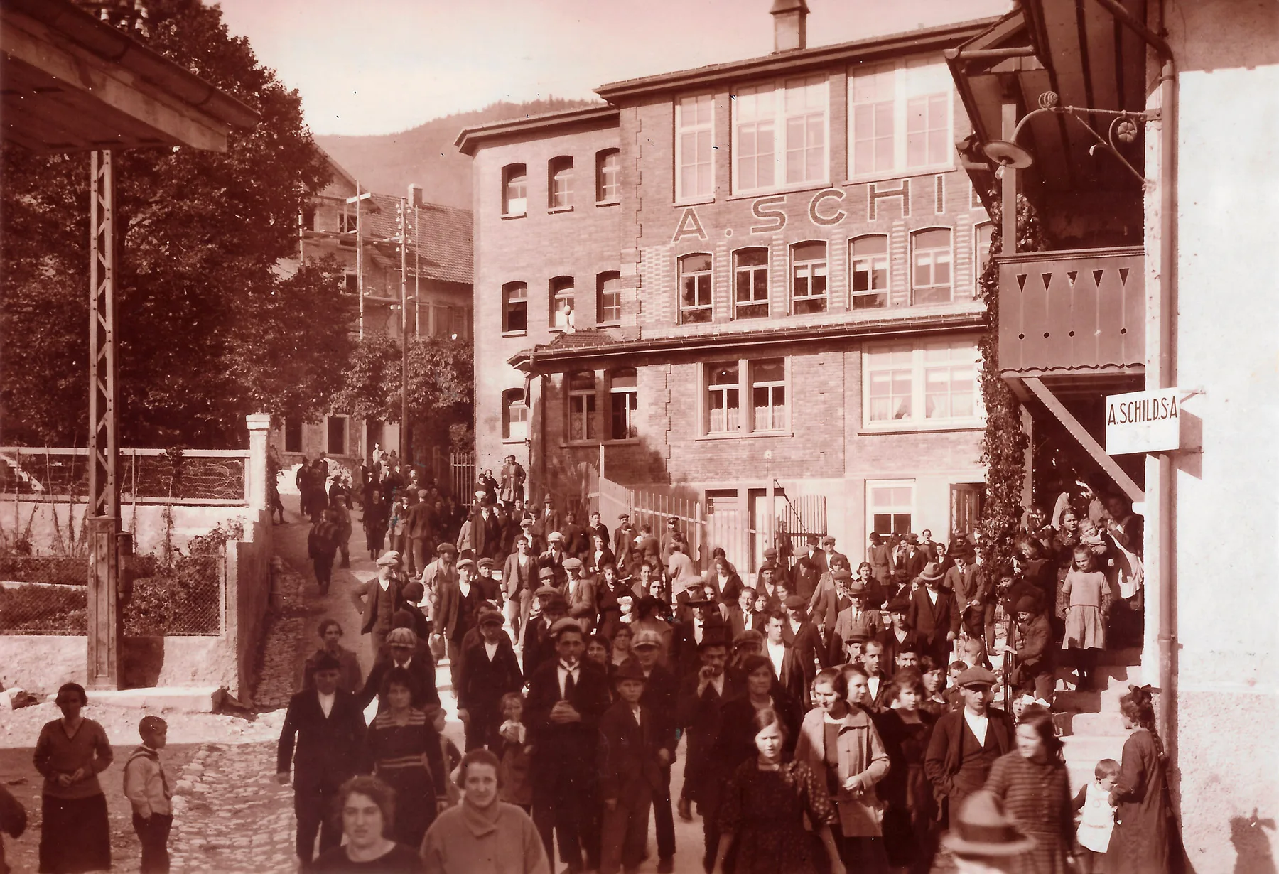 Uhrenarbeiterinnen und Uhrenarbeiter der A. Schild SA (Assa) verlassen nach Feierabend die Fabrik. Foto aus dem Jahr 1924.