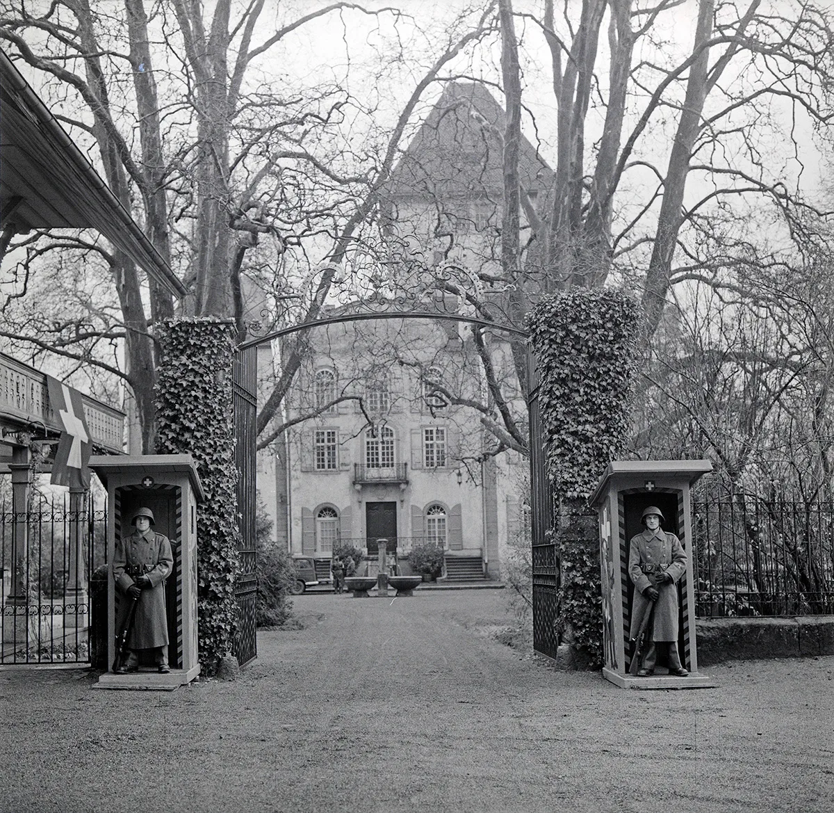 Wachtposten flankieren das Zugangstor zum Hof von Schloss Jegenstorf. Neben Polizisten waren auch Soldaten im Einsatz. Foto von Björn Lindroos, 1954.