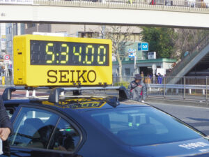 Mobile Zeitanzeige mit Werbung von Seiko am Marathon in Tokio, 2016.