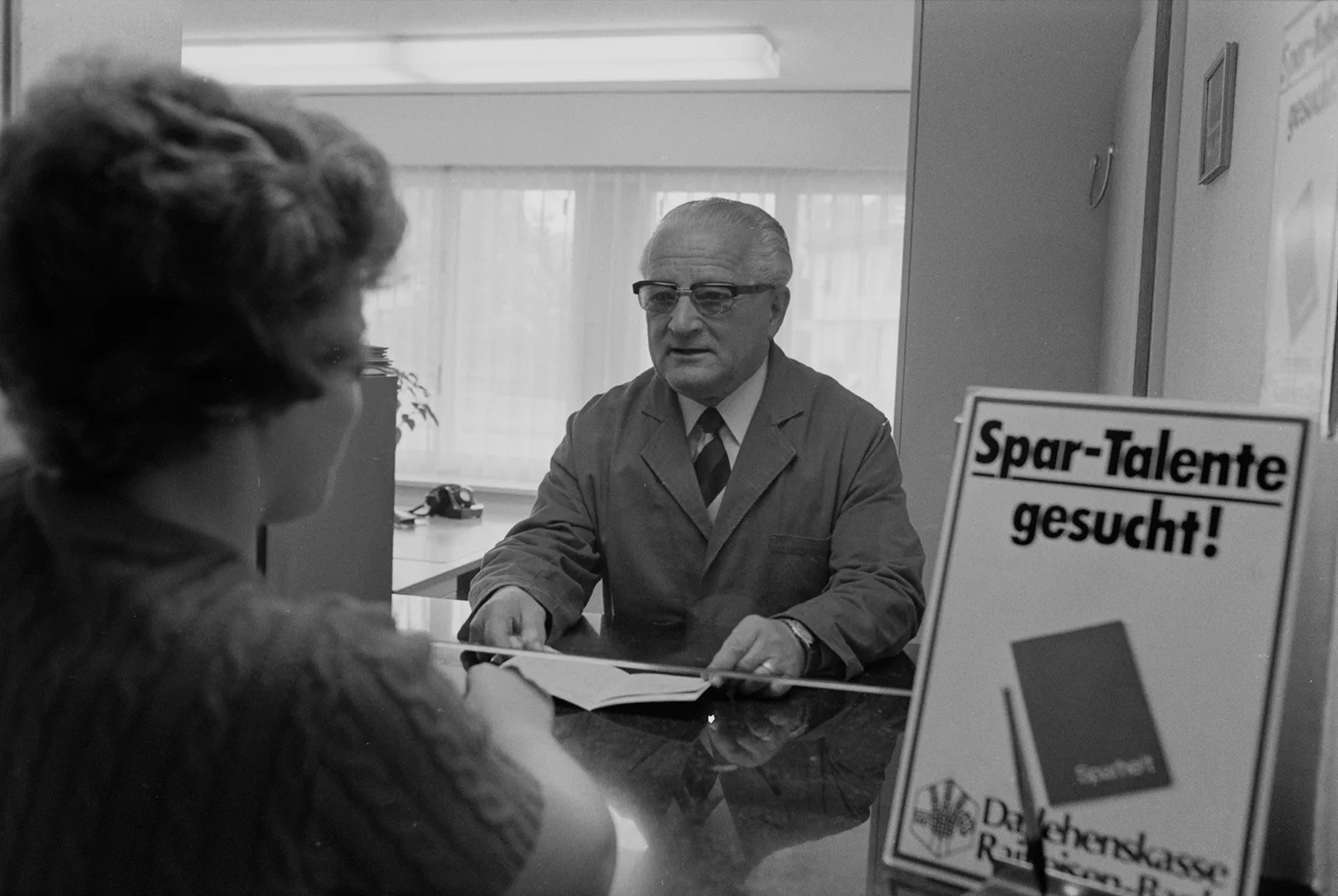 Sign at the Raiffeisen counter in Ganterschwil, St. Gallen, proclaiming ‘Talented savers wanted!’, 1975.