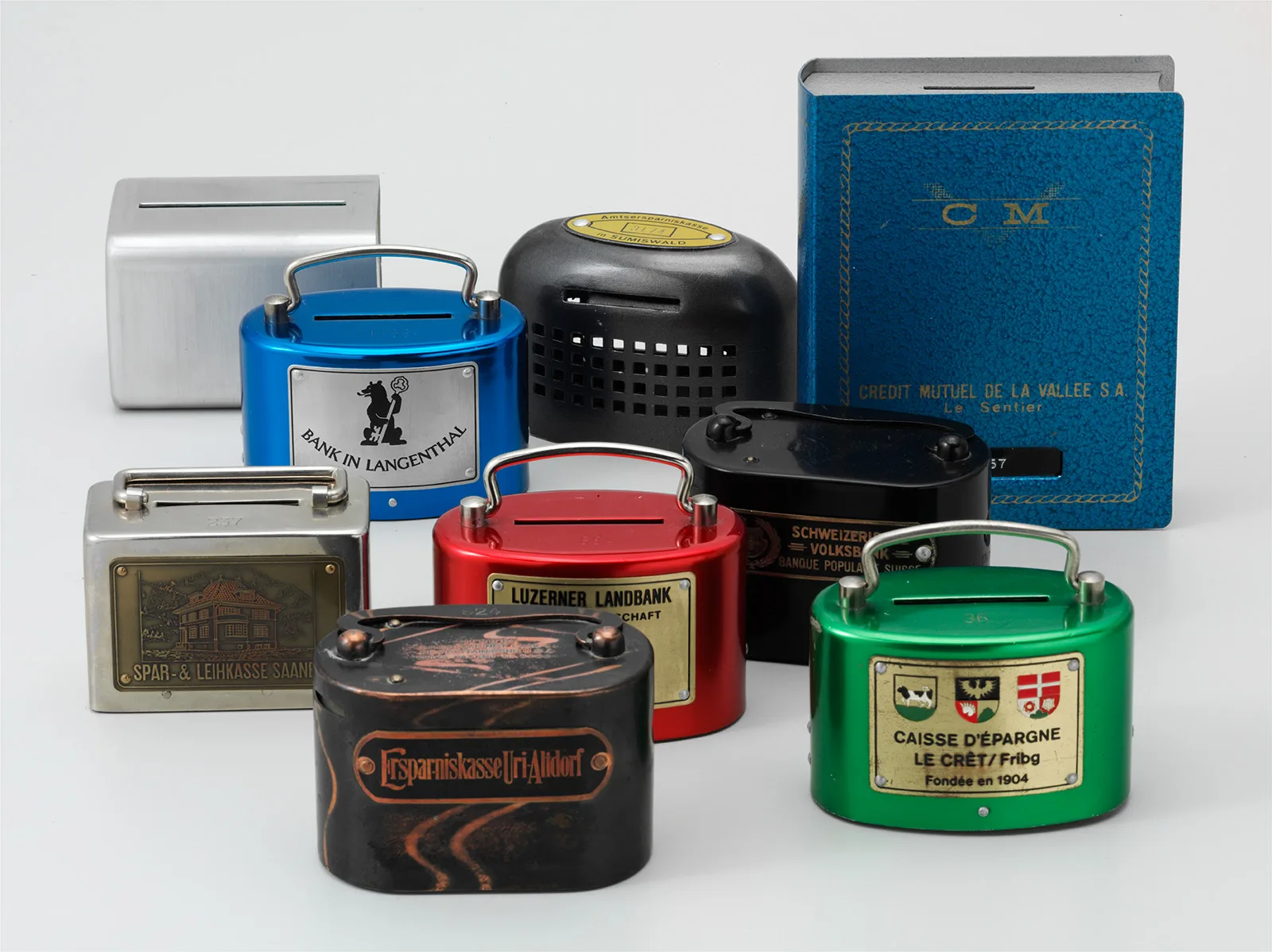 A selection of 20th-century money boxes. The one at back right is meant to be displayed in a bookcase.