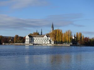 Blick vom rechten Ufer über den See auf das Konstanzer Inselhotel im Herbst 2023. Heute wird das im Besitz der badischen Staatsbrauerei Rothaus befindliche Hotel von der Steigenberger-Gruppe betrieben.