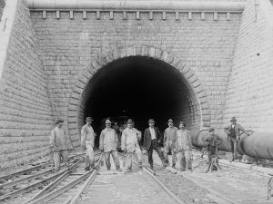 Group of workers in front of the completed south portal of the Hauenstein base tunnel.