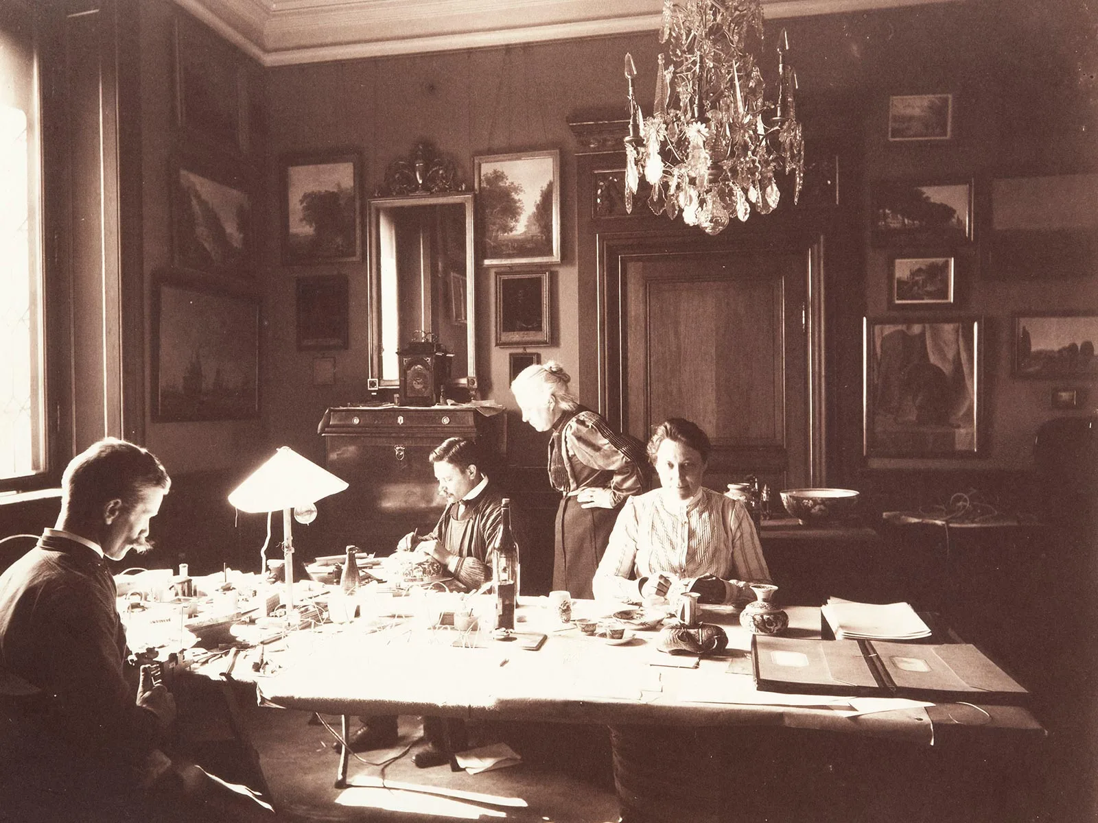 Wilhelmina (stehend) überwacht 1907 die Inventarisierung von Sammlungs- und Fundobjekten.
