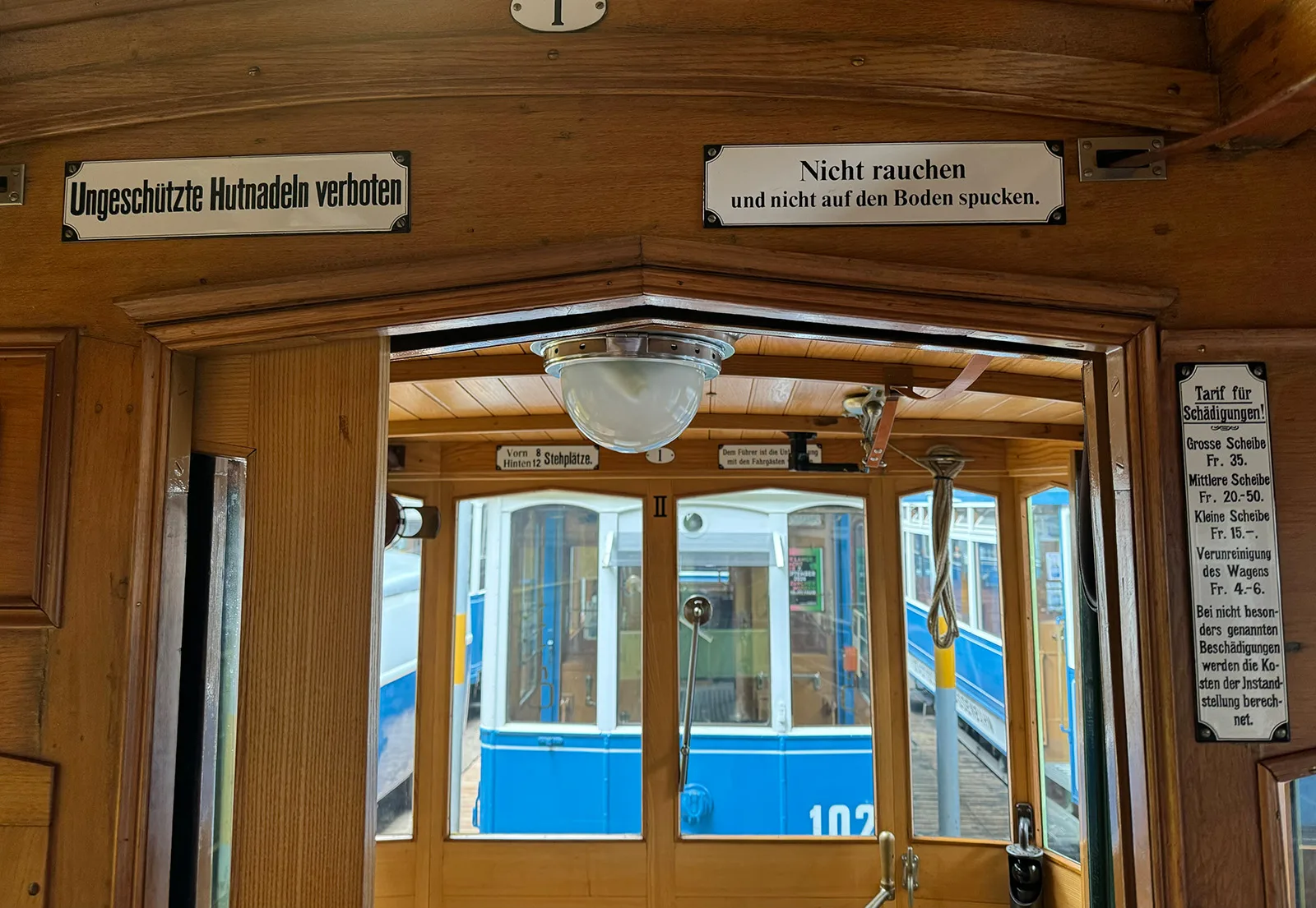 In den Zürcher Tram wiesen Emailtafeln auf unterschiedliche Verbote hin. Eine ungeschützte Hutnadel konnte mit einer Busse von bis zu 10 Franken bestraft werden. Interieur der Strassenbahn Zürich – Oerlikon – Seebach (ZOS), um 1913–1930.