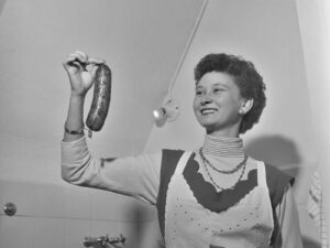 Cuisinière montrant une saucisse, 1955.