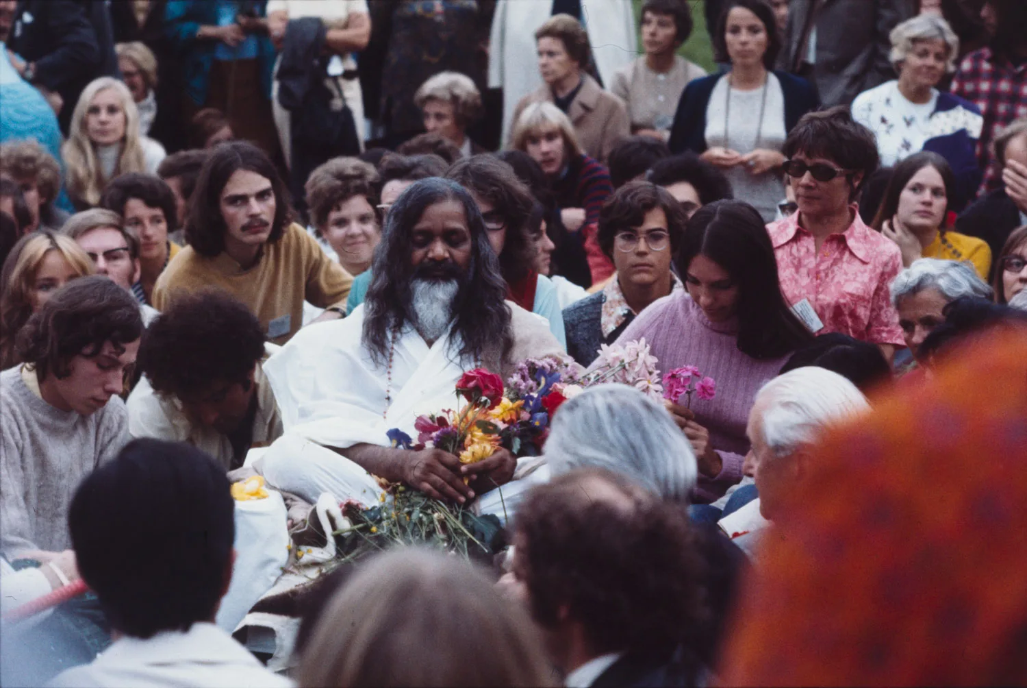 Guru Maharishi Mahesh Yogi mit einigen Anhängerinnen und Anhängern, 1970.