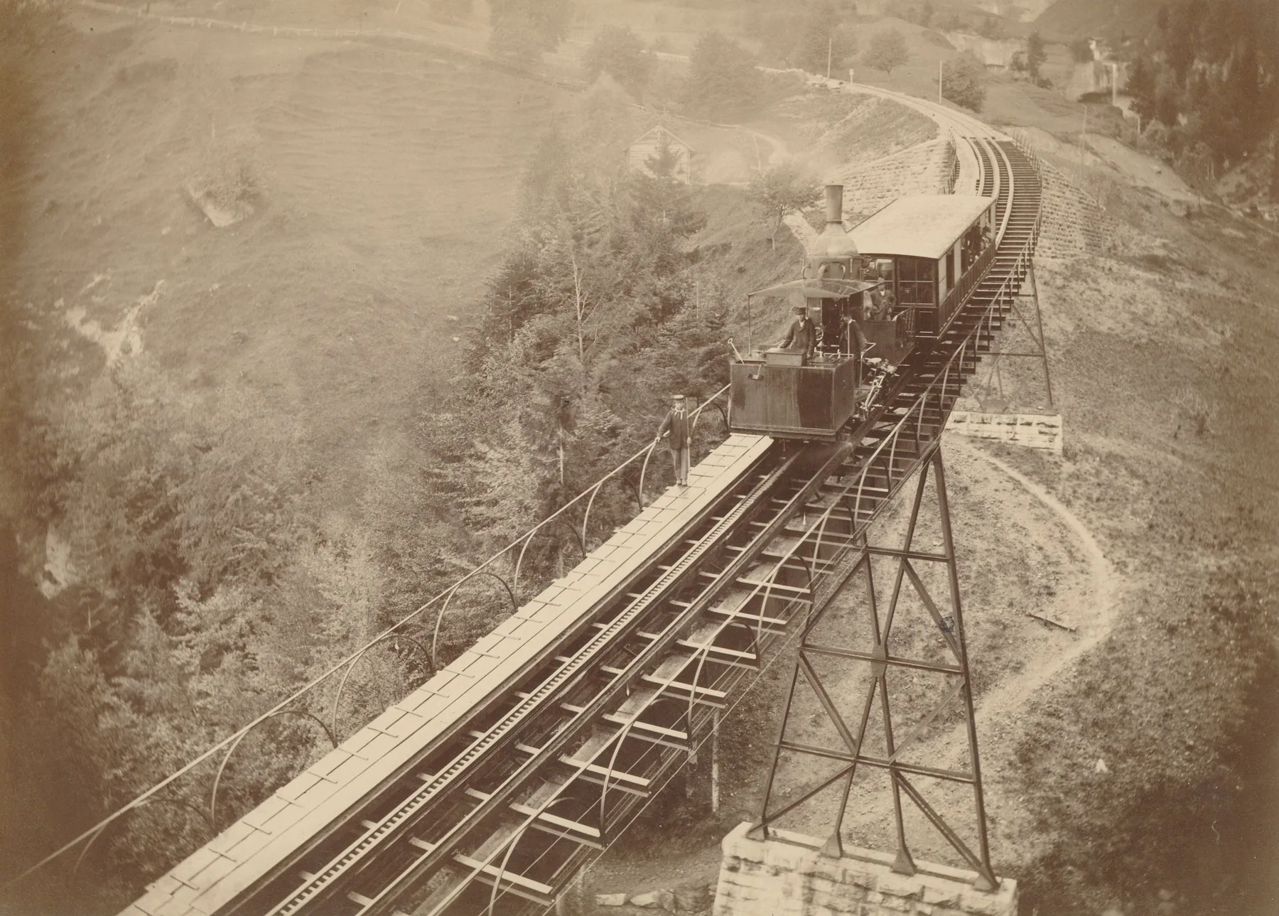 Zugskomposition der Vitznau-Rigi-Bahn um 1875 auf der Schnurtobelbrücke mit gut sichtbarer Leiterstange des «Systems Riggenbach». Ein Zugsläufer ging voraus, um den Lokführer vor Gefahren zu warnen oder Hindernisse vom Gleis zu räumen.