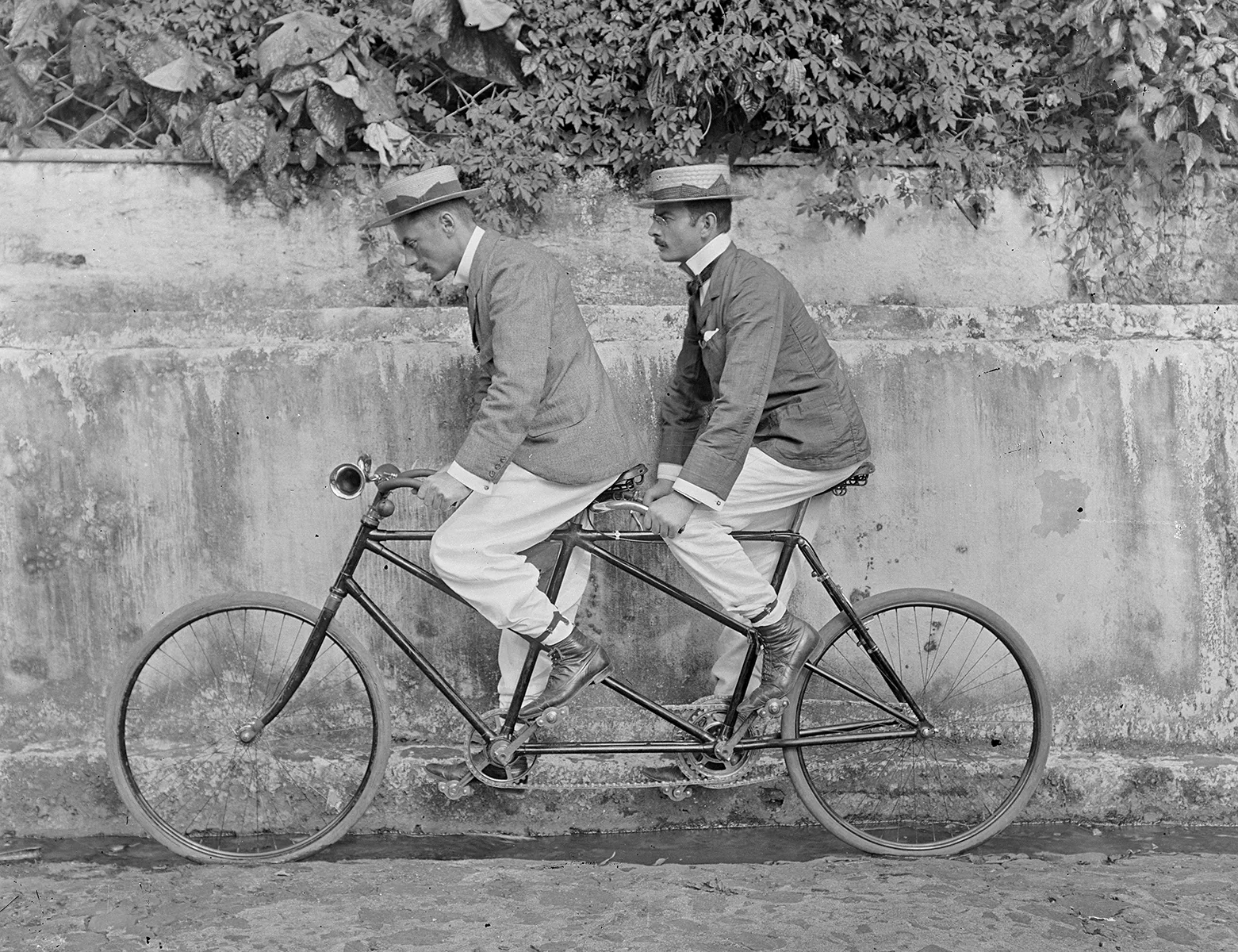 Zwei Männer auf einem Tandem, um 1912.