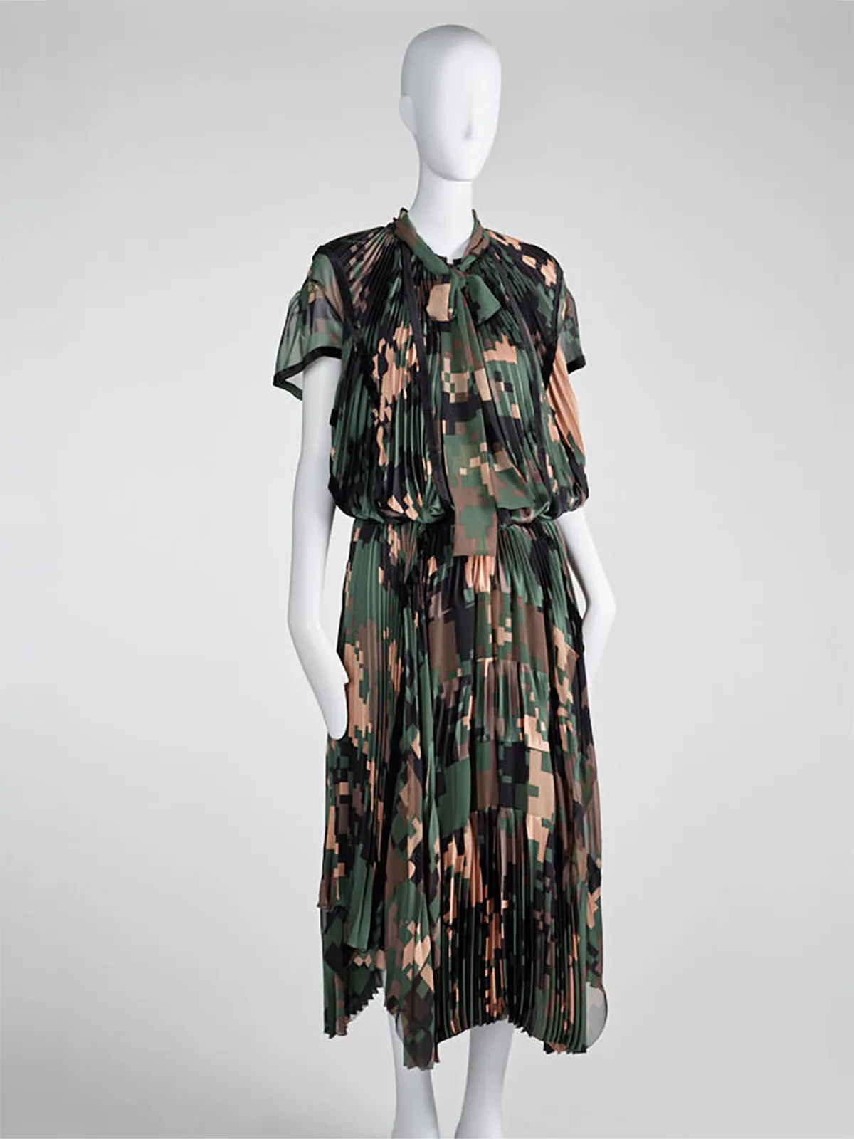 Camouflage als Haute Couture: Chitose Abe verarbeitet in ihrer Herbst/Winter-Kollektion 2017 für Sacai ein Tarnmuster zu einem plissierten zweiteiligen Kleid.